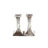 A pair of late Victorian silver Corinthian column candlesticks, raised on stepped beaded bases,