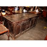 A large 18th Century oak coffer, with carved frieze above five panel front raised on block supports,