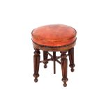 A 19th Century mahogany stool, having red leather revolving top raised on turned tapering reeded