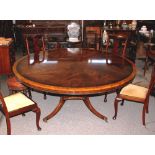 A Regency style mahogany and satin wood cross banded circular dining table, raised on quadruple