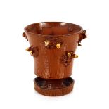 An unusual Staffordshire slipware vase, with raised tree stump decoration and circular spread