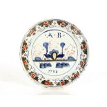 A rare 18th Century Bristol Delftware polychrome plate, naively painted with initials A.B. dated