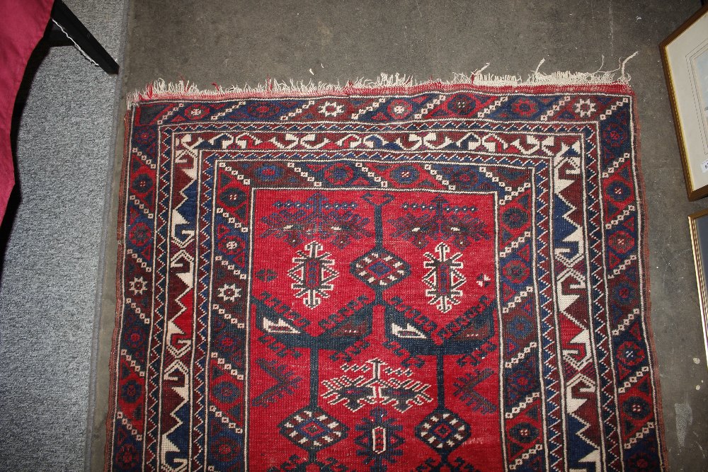 A Middle Eastern wool rug, of Caucasian design having stylised motifs on a brick red ground, 186cm x - Image 4 of 5