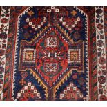 An Eastern Caucasian design wool rug, having central lozenge panel within stylised borders, 129cm