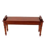 A mahogany Regency style window seat, the scroll ends raised on turned tapering supports terminating