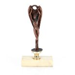 A copper car mascot type figure, of a lady with outstretched arms holding a wreath on onyx base,