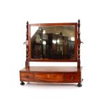 A Georgian mahogany bow fronted swing toilet mirror, on three drawer box base, raised on bun feet,