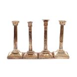 Two pairs of plate on copper Corinthian column candlesticks, raised on square gadrooned bases (one
