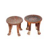 A pair of wooden ethnic four legged stools, with dished tops and stylised decoration, 28.5cm dia.