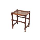 A Victorian low stool, raised on turned baluster supports and castors; a cane seat stool raised on