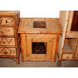 An unusual 19th Century bamboo sloping topped cabinet, having central lacquered panels decorated