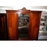 A 19th Century French walnut break front wardrobe, the pediment surmounted by gilded cresting,