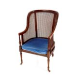 A late 19th Century mahogany framed Bergere armchair, raised on tapering turned front supports