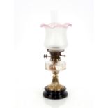 A Victorian oil lamp, having brass column, clear glass reservoir and tinted shade, 57cm high overall