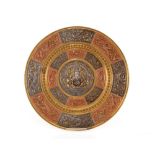 An Indian brass, copper and white metal circular plaque, with raised central boss of Ganesh