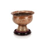 An Eastern copper bowl, with foliate engraved decoration on wooden plinth, 22cm dia.