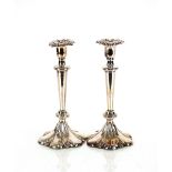 A pair of plated candlesticks, with detachable sconces raised on tapering columns and spread petal