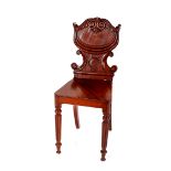 A 19th Century mahogany hall chair, in the Gillows style having carved shield back raised on