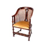 An oak tub shaped Bergere chair, raised on turned baluster front supports united by a Carolean style