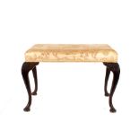 A George II style mahogany footstool, the upholstered seat raised on cabriole supports, 76cm wide;