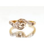 An 18ct gold and platinum cross over ring, set with diamonds, size "J", 2.5gms total weight