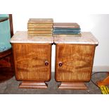 A pair of French Art Deco walnut bedside cabinets, surmounted by marble tops, raised on shaped
