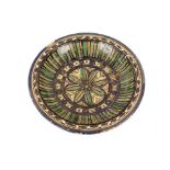 A North African glazed pottery shallow dish, having multi coloured stylised decoration, 35cm dia.