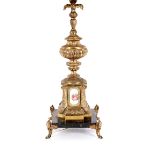 An ornate gilt metal table lamp, decorated with porcelain plaques raised on marble plinth base