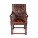 A 17h Century and later carved oak Wainscot chair, having profusely carved panelled back, solid seat