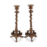 A pair of 19th Century bronze candlesticks, with serpent and vine leaf decoration above a tripod