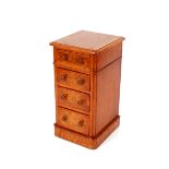 A pair of burr oak and cross banded pedestal four drawer bedside chests, raised on plinth bases,