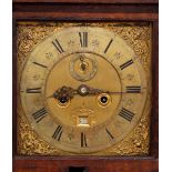 An 18th Century oak cased long cased clock, the hood surmounted by stepped pediment and gilt finials