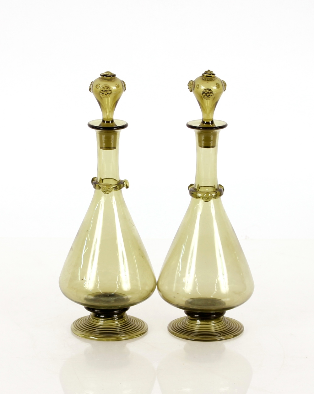 A pair of continental green glass decanters, having raised Prunts decoration for the necks and