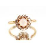 A 18ct gold ring, set opal surrounded by diamonds, size "L"