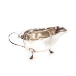 A silver sauce boat, Sheffield 1937, with serrated border and loop handle raised on hoof feet