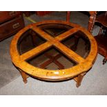 A 20th Century walnut and plate glass coffee table, with segment top raised on square tapering