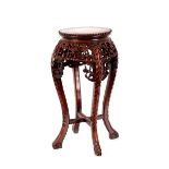 An early 20th Century Chinese carved hardwood and marble inset cache pot stand, having pierced