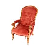 A Victorian mahogany armchair, pink Dralon upholstered back, seat and armrests, raised on turned