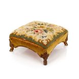 An unusual Victorian footstool, with embroidered upholstery and raised on brass hoof feet