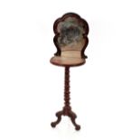 A Victorian walnut shaving stand, surmounted by a shaped mirror, raised on barley twist supports and