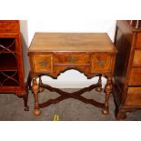 A walnut and cross banded low boy, fitted three drawers over arched frieze raised on turned cup