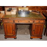A Victorian golden oak and ebonised pedestal writing desk, the leather inset top above three