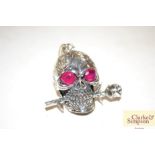 A silver and ruby type skull and rose pendant