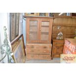 A glazed pine cupboard on chest fitted two short a