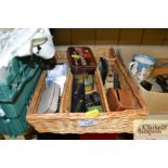 A wicker tray of various vintage tins, coinage, sh