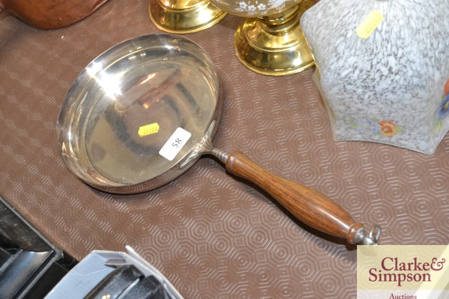 A heavy plated frying pan with turned wooden handl