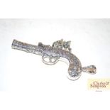 A silver pendant in the form of a gun