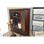 A carved wooden hanging corner cupboard enclosed b