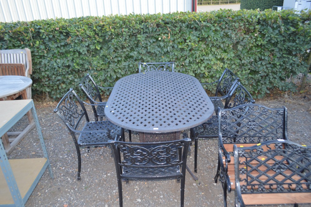 A metal garden table with a set of six chairs