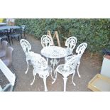 An ornate garden table and a set of six chairs